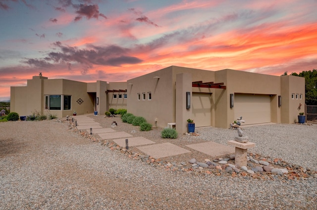 pueblo-style house featuring a garage