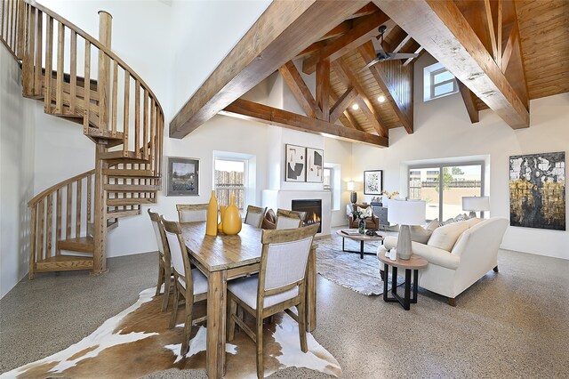 dining room featuring ceiling fan, beamed ceiling, high vaulted ceiling, and carpet floors