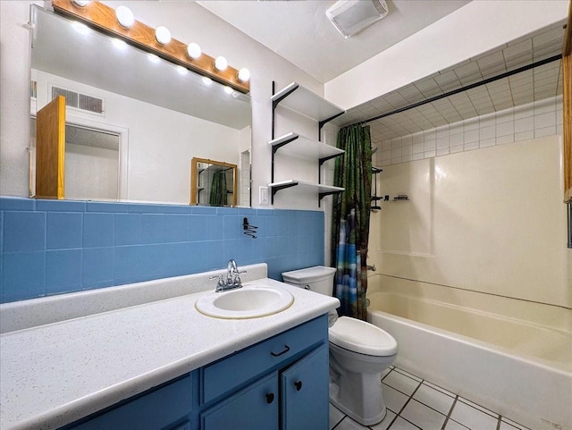 full bathroom with tile patterned floors, toilet, vanity, visible vents, and tile walls