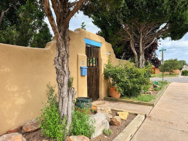 community / neighborhood sign featuring a gate and fence
