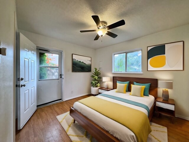 bedroom with a textured ceiling, ceiling fan, and hardwood / wood-style flooring