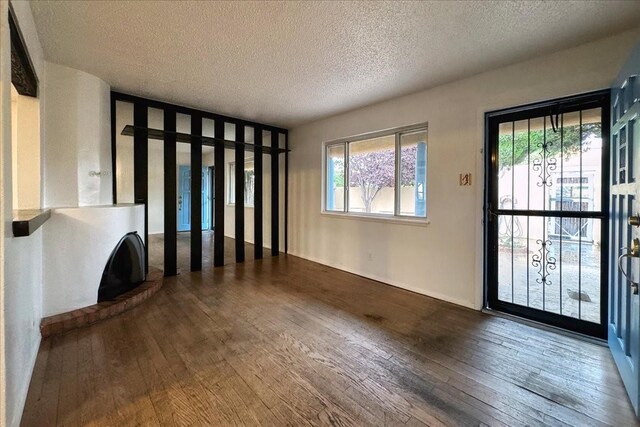 interior space featuring a textured ceiling and dark hardwood / wood-style floors