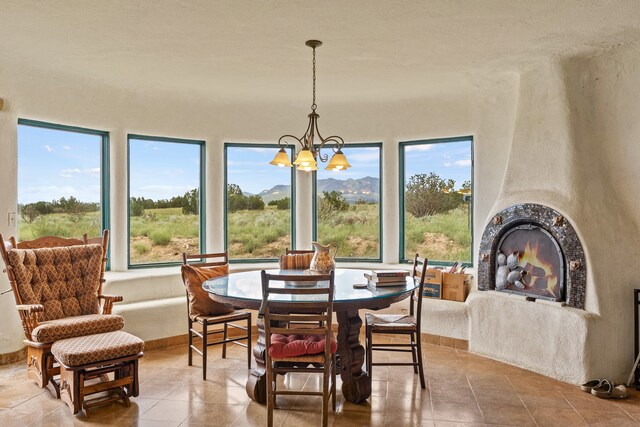 115 Waldo Mesa, Madrid, NM 87010 - tiled dining area featuring a fireplace and a chandelier