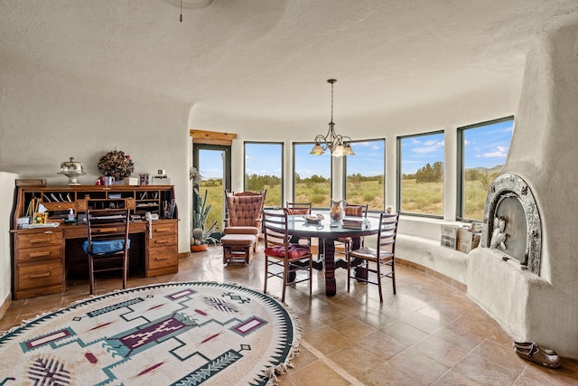 115 Waldo Mesa, Madrid, NM 87010 - tiled dining space featuring a textured ceiling and an inviting chandelier