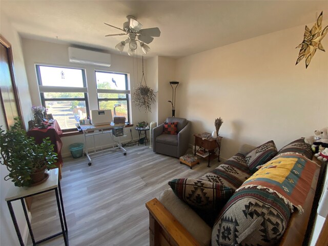 living room featuring a wall mounted air conditioner, ceiling fan, and light wood-type flooring