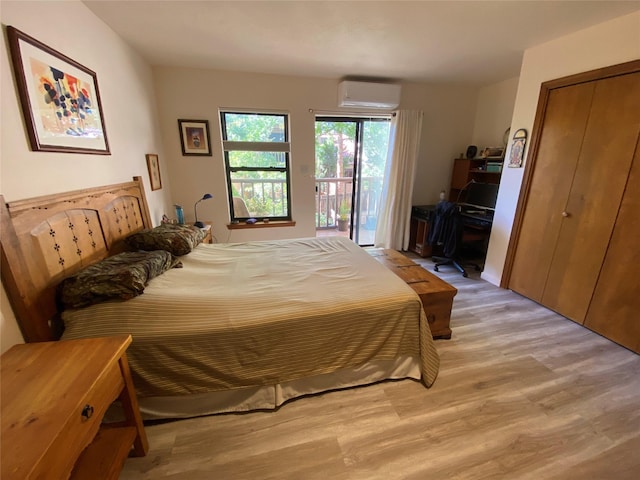 bedroom with access to exterior, light wood-style flooring, and a wall mounted air conditioner