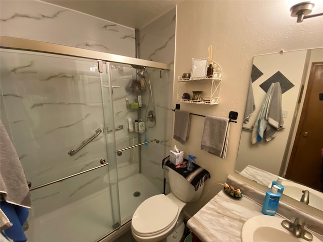 bathroom with a marble finish shower, toilet, and vanity