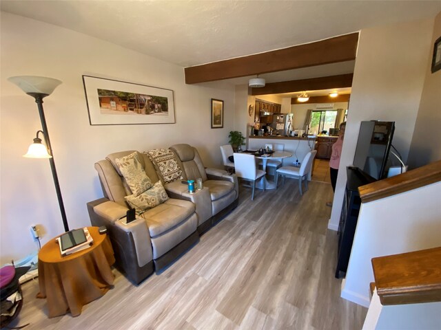 living room with beamed ceiling and wood-type flooring