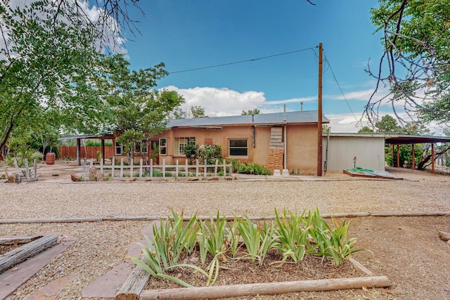 back of house featuring a carport