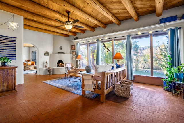 sunroom with a healthy amount of sunlight, wood ceiling, a large fireplace, and beam ceiling