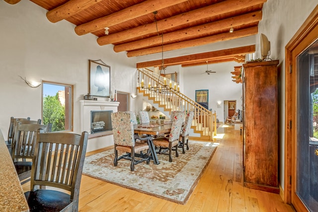 dining room featuring beamed ceiling, light hardwood / wood-style flooring, and wooden ceiling