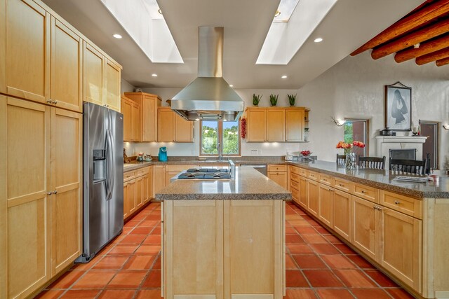 kitchen with island range hood, tile patterned floors, stainless steel appliances, and light brown cabinetry