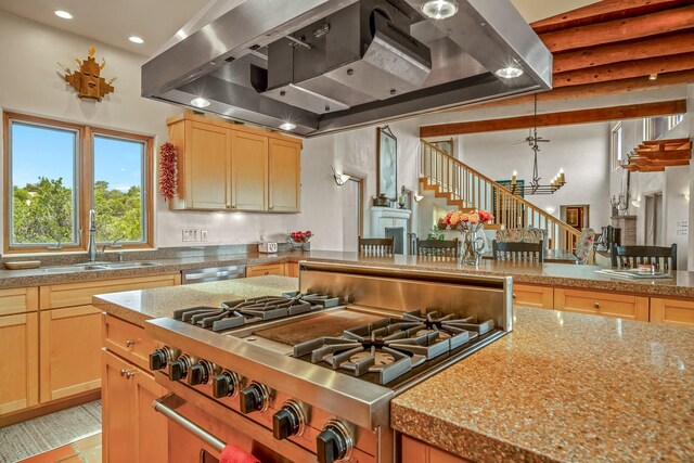 kitchen featuring a notable chandelier, dishwasher, sink, gas range, and wall chimney exhaust hood