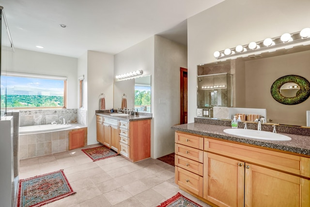 bathroom featuring tile patterned floors, vanity, and a relaxing tiled tub