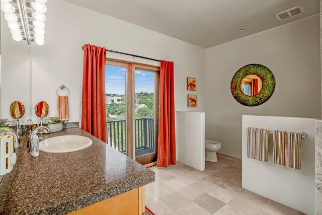 bathroom with vanity, tile patterned flooring, and toilet