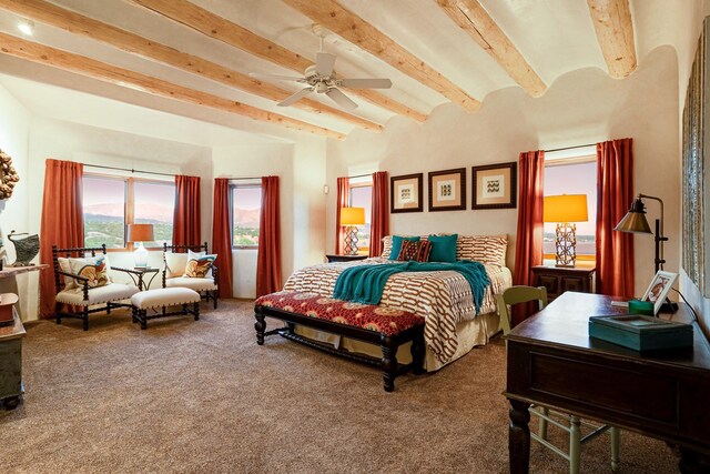 carpeted bedroom featuring beam ceiling and ceiling fan