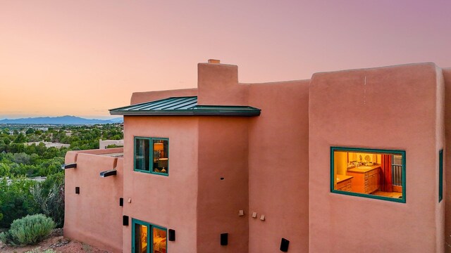 property exterior at dusk with a mountain view