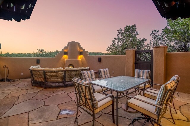 patio terrace at dusk featuring an outdoor hangout area