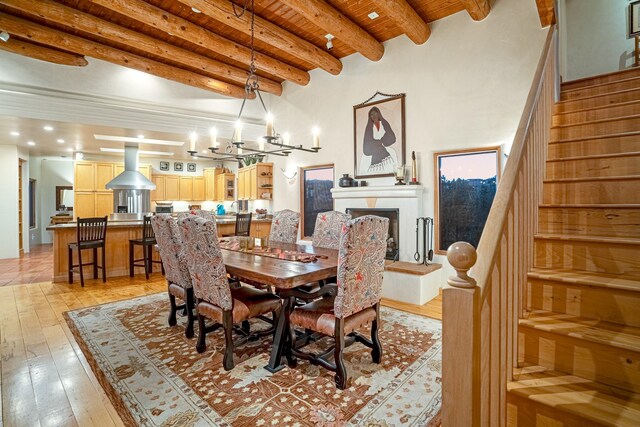 dining room with beamed ceiling, a chandelier, light hardwood / wood-style floors, and wood ceiling