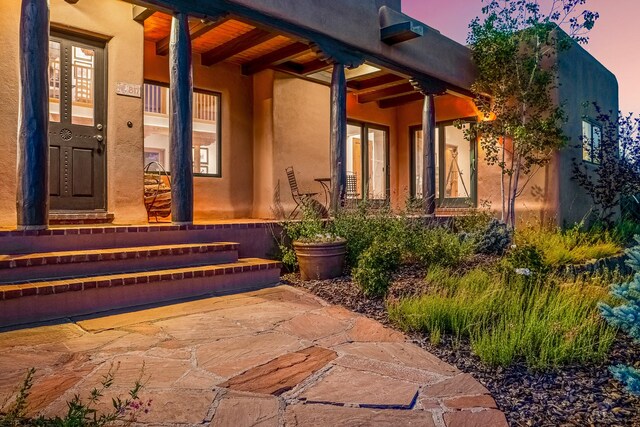 exterior entry at dusk with a patio