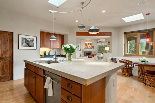 kitchen with a skylight, light hardwood / wood-style flooring, sink, and dishwasher