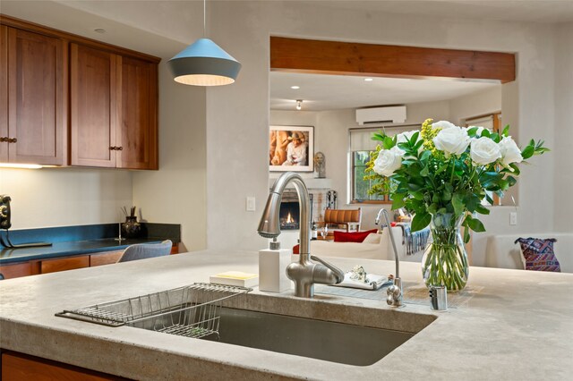 kitchen with sink, a wall mounted air conditioner, and pendant lighting