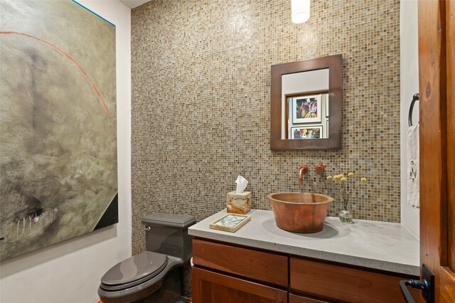 bathroom featuring backsplash, toilet, and vanity