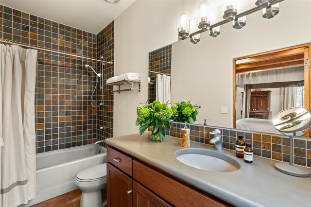 full bathroom featuring shower / tub combo, vanity, decorative backsplash, and toilet