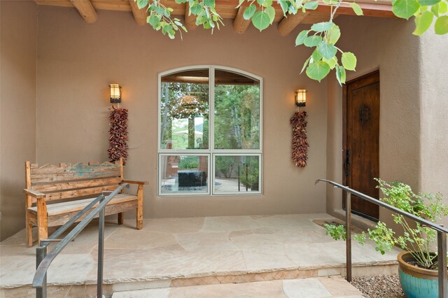 view of exterior entry with a patio area