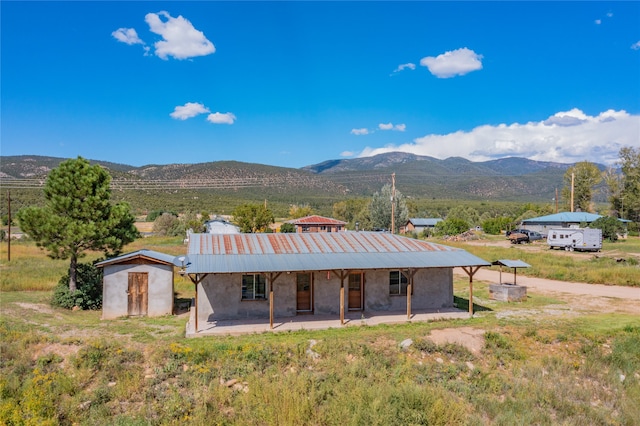 rear view of property with a mountain view and a patio area