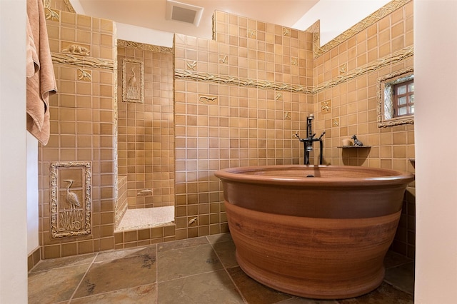 bathroom with vanity, a shower, and tile walls