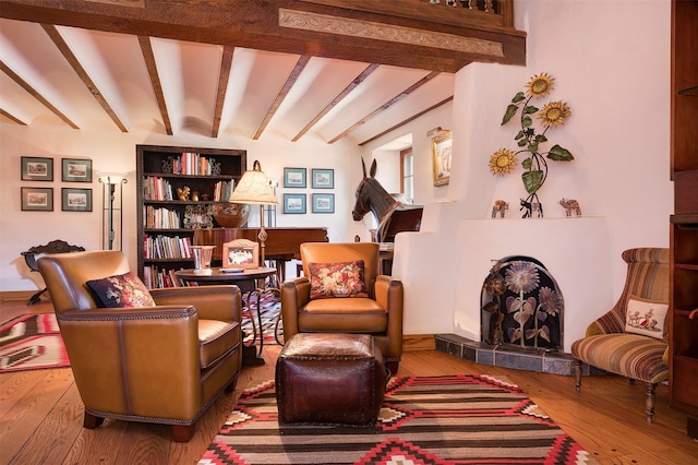 sitting room featuring hardwood / wood-style flooring and beamed ceiling