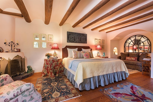 bedroom featuring hardwood / wood-style flooring and beamed ceiling