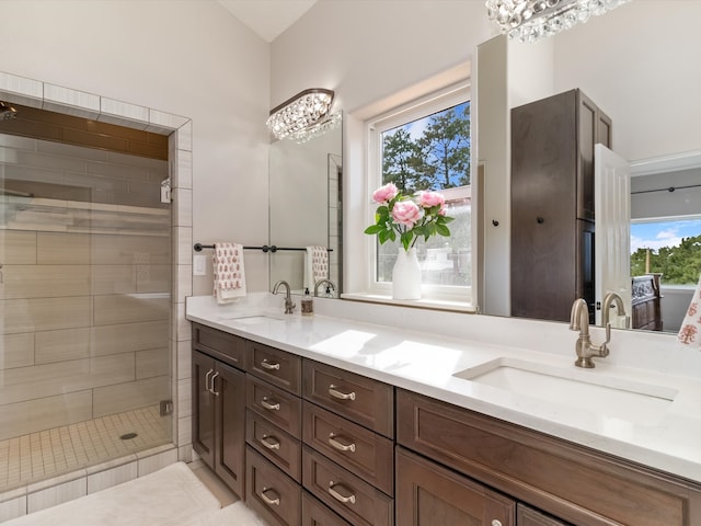 bathroom with double sink vanity, walk in shower, and an inviting chandelier