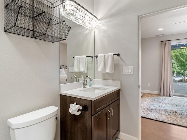 bathroom with hardwood / wood-style flooring, vanity, and toilet