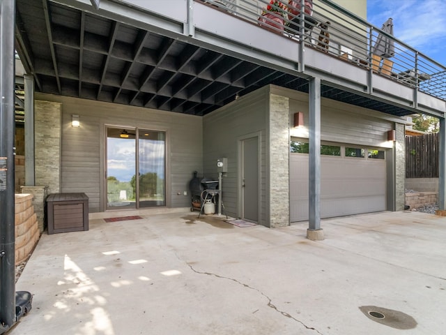 view of patio with a balcony and a garage