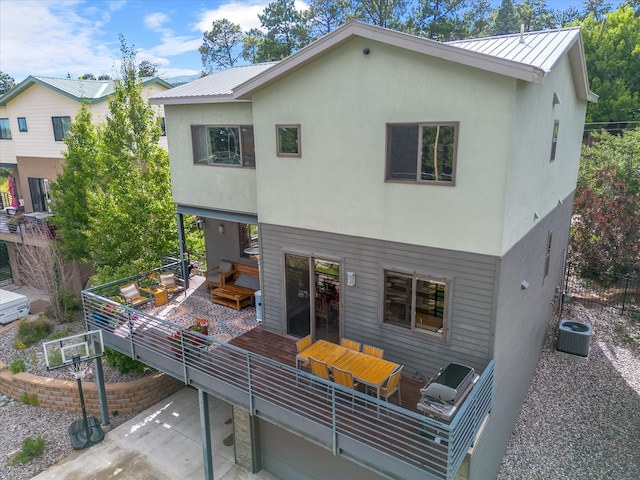 rear view of property with central AC unit and a patio area