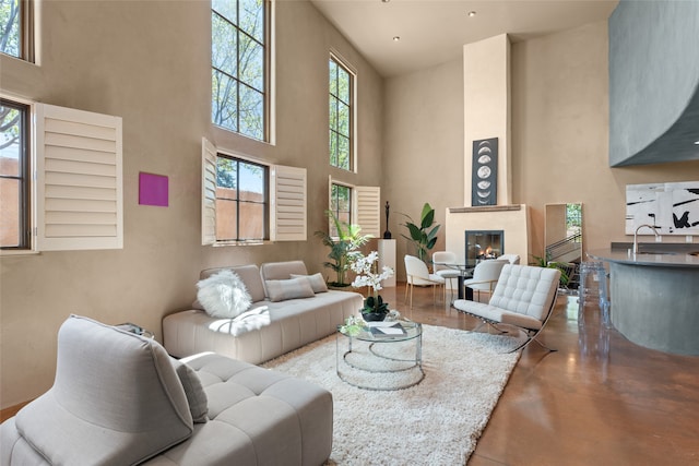 living room with a high ceiling, sink, and concrete floors