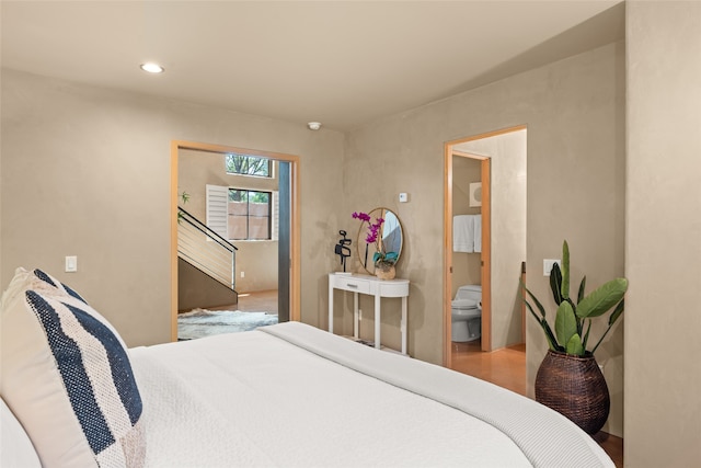 bedroom featuring wood-type flooring and ensuite bathroom