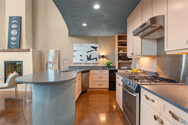 kitchen featuring appliances with stainless steel finishes, dark tile patterned flooring, a breakfast bar area, and sink