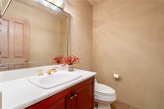 bathroom with toilet, vanity, and tile patterned floors