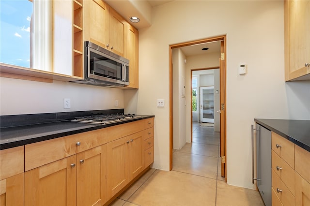 kitchen featuring light brown cabinets, stainless steel appliances, and light tile patterned floors