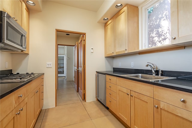 kitchen with sink, light tile patterned floors, stainless steel appliances, and light brown cabinets