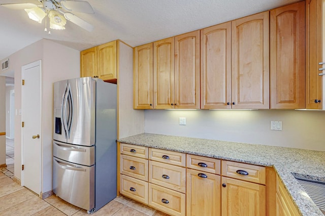 kitchen featuring ceiling fan, light brown cabinets, stainless steel refrigerator with ice dispenser, and light stone counters