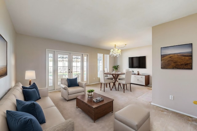 living room featuring french doors, light colored carpet, and a chandelier