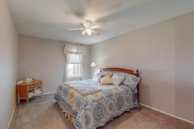 carpeted bedroom featuring ceiling fan and a textured ceiling