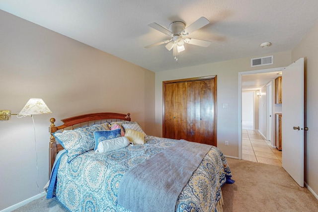 carpeted bedroom featuring ceiling fan and a closet