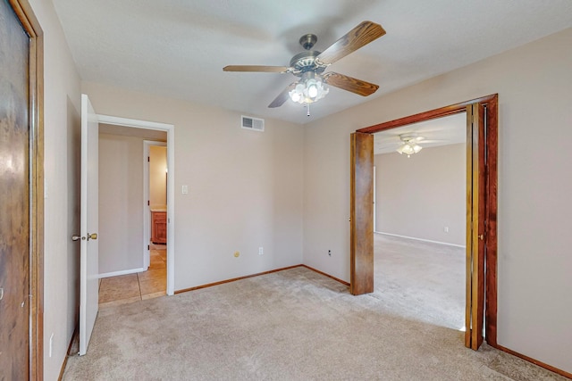 unfurnished bedroom featuring ceiling fan and light colored carpet