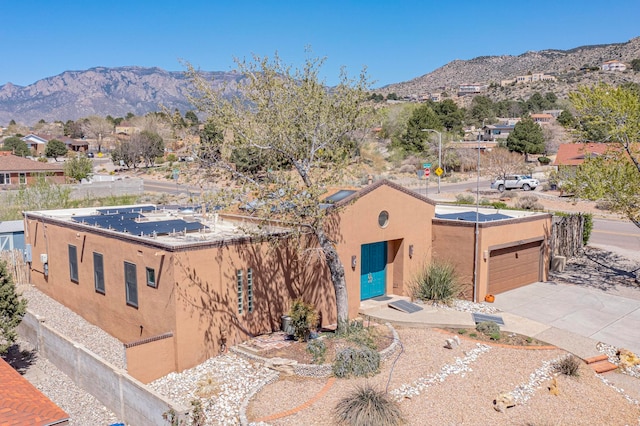 adobe home featuring a garage and a mountain view