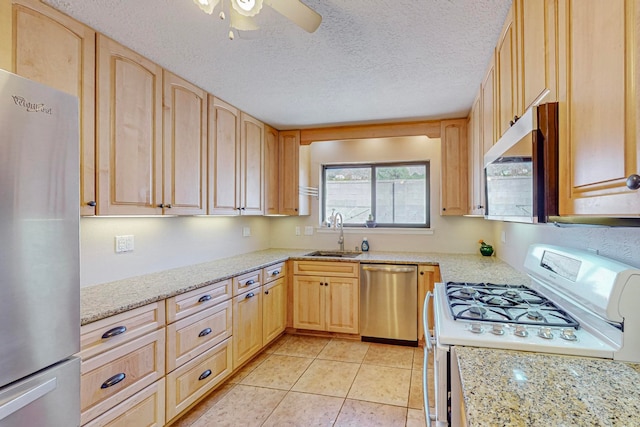 kitchen featuring appliances with stainless steel finishes, light brown cabinets, a textured ceiling, ceiling fan, and sink